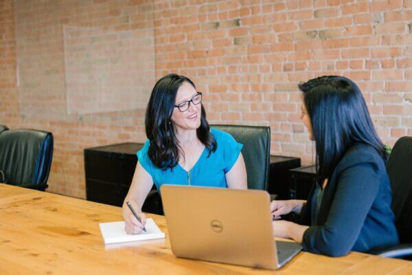 Two members of a finance team work on their NetSuite strategy in a boardroom