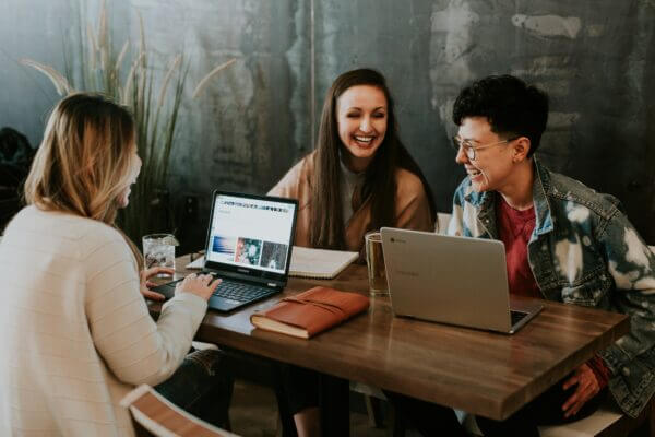 Three nonprofit colleagues laughing as they work with Blackbaud together