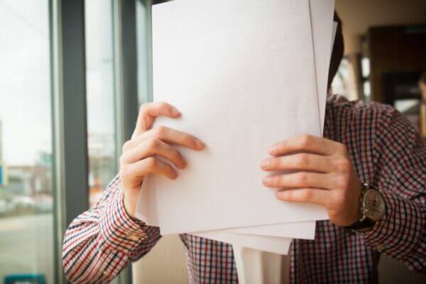 Finance team leader holds a stack of documents that should be digitized