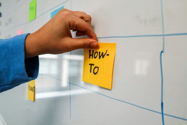 Hand posting note on a whiteboard, how to speed up task automation