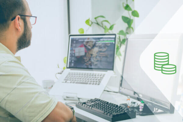 A man sits at a computer working on fundraising event automation