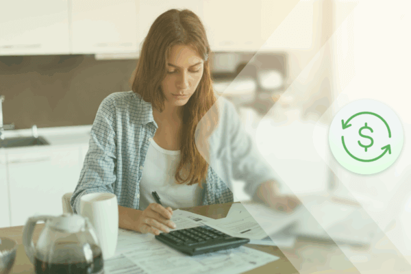 A woman sits at a desk with a calculator
