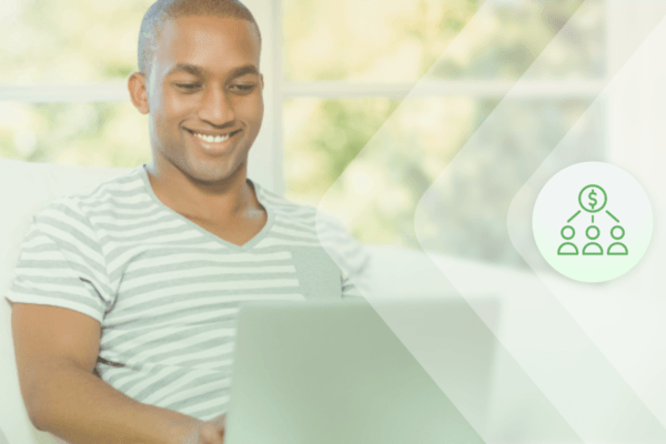 Man sits smiling at his laptop